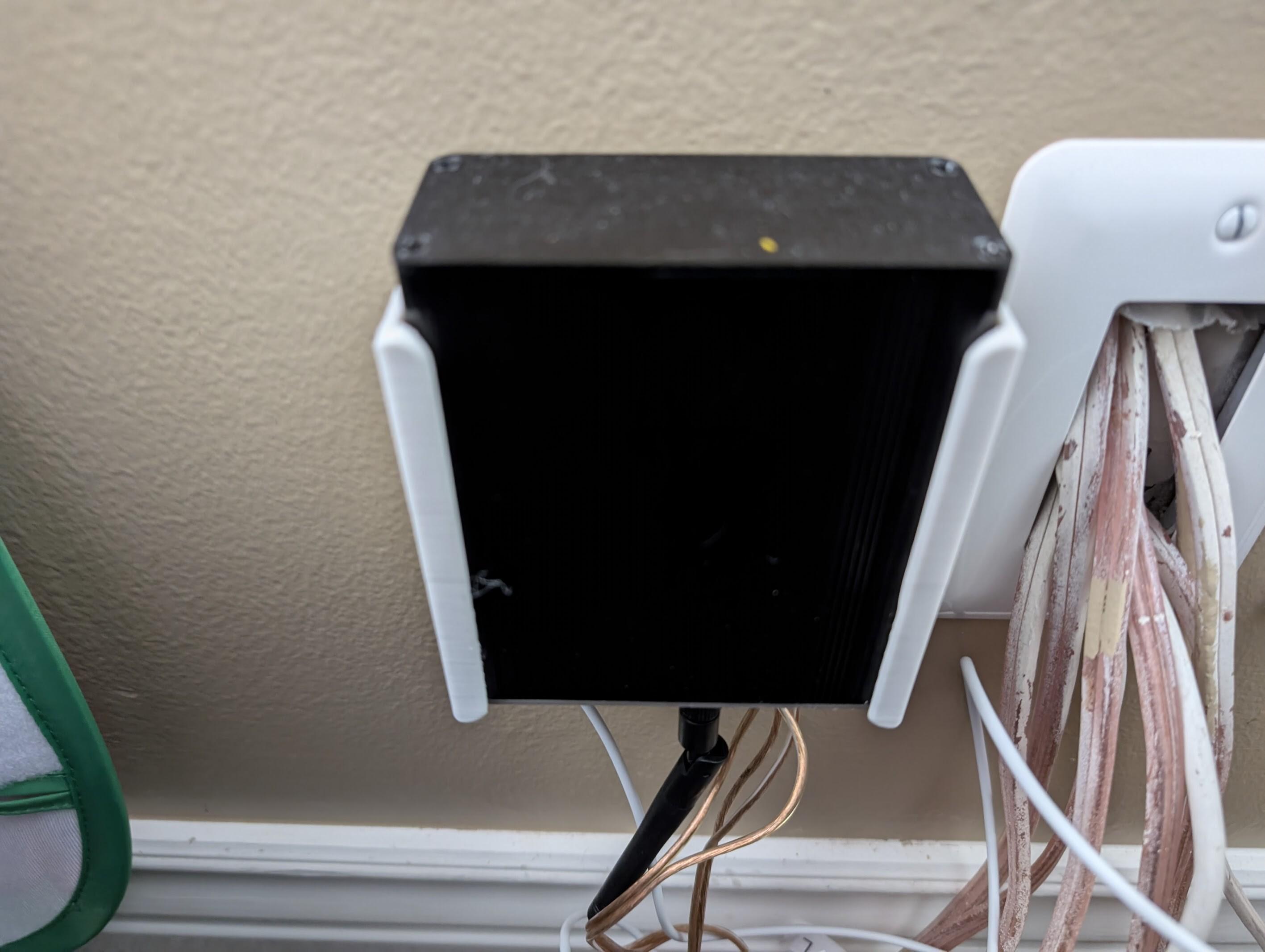 A louder-esparagus sitting in a 3D printed bracket, mounted on a wall.